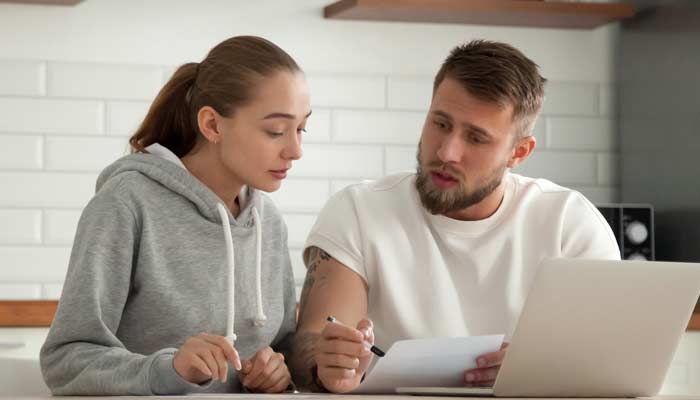 couple sitting at computer trying to figure out their bills