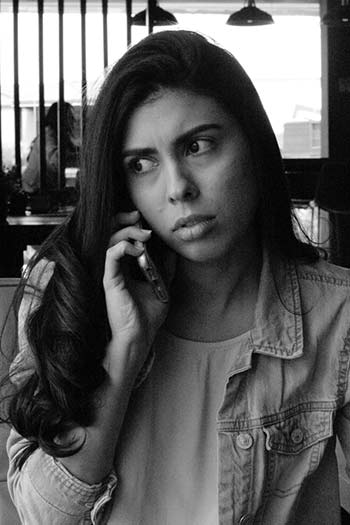 woman looking skeptical as she listens to a phone call