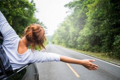 woman riding in a car on a summer day